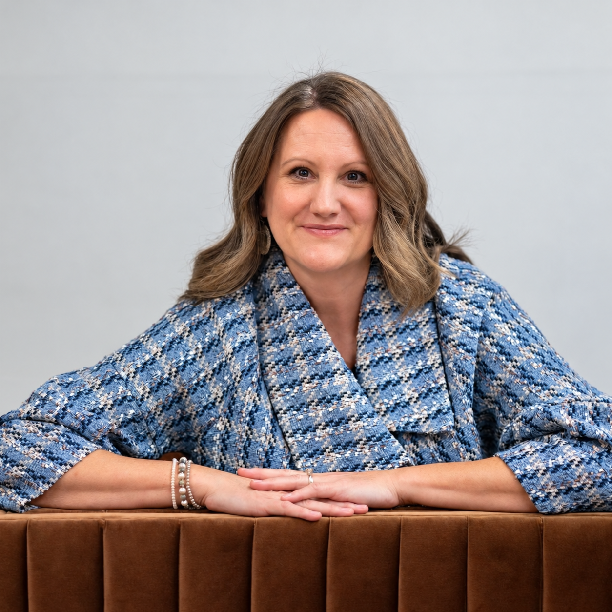 Leah Boatright smiling across the back of a brown chair